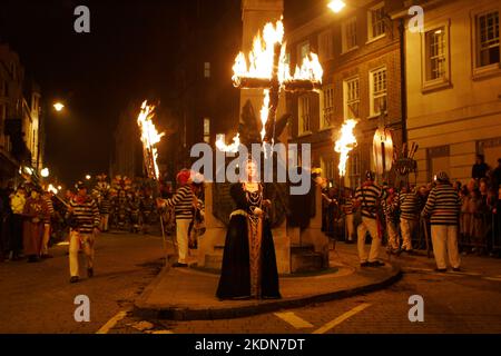 Après avoir déposé une couronne au mémorial de guerre, la Borough Bonfire Society s'est habillée de costume Tudor ou de passeurs, de légères croix et de torches dans le cadre des processions tortueuses des pompiers à travers les rues de Lewes sur 5 novembre, Guy Fawkes Night. Banque D'Images