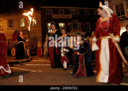 Les mères et les enfants Tudor passent devant le monument commémoratif de guerre après avoir déposé une couronne au monument commémoratif de guerre. La Borough Bonfire Society vêtue de costume Tudor ou de passeurs, de croix légères et de torches dans le cadre des processions flamboyantes des pompiers à travers les rues de Lewes sur 5 novembre, Guy Fawkes Night. Banque D'Images