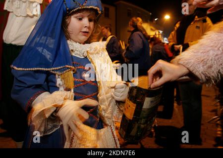 Mettre de l'argent dans la boîte de collecte de la Bonfire Society d'un enfant. Tout l'argent recueilli dans la rue est donné à une œuvre de charité. Les mères et les enfants Tudor passent devant le monument commémoratif de guerre après avoir déposé une couronne au monument commémoratif de guerre. La Borough Bonfire Society vêtue de costume Tudor ou de passeurs, de croix légères et de torches dans le cadre des processions flamboyantes des pompiers à travers les rues de Lewes sur 5 novembre, Guy Fawkes Night. Banque D'Images