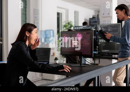 Développeur d'applications asiatiques ayant piraté le serveur Web, analysant l'erreur critique sur la programmation de l'écran d'ordinateur dans le bureau. Développeur de logiciels essayant de résoudre le problème de piratage, sécurité de pare-feu. Banque D'Images