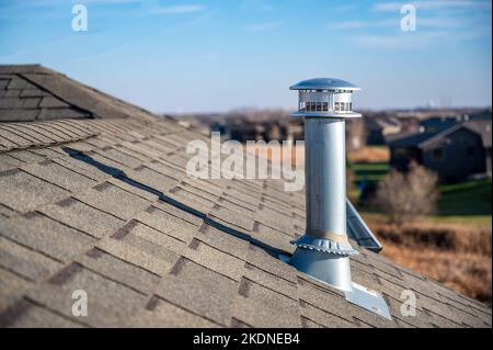 Vue latérale d'une cheminée d'échappement en métal galvanisé sur un toit en asphalte avec un capuchon de pluie Banque D'Images