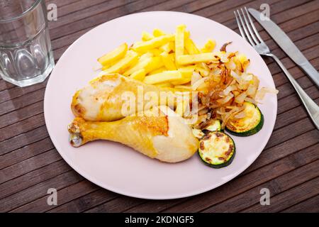 Cuisses de poulet avec pommes de terre frites et courgettes Banque D'Images