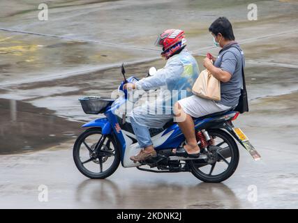 SAMUT PRAKAN, THAÏLANDE, SEP 26 2022, Mototaxi conduit avec un passager sous la pluie Banque D'Images