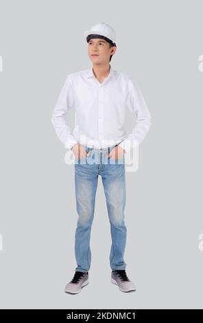 Portrait le jeune homme asiatique est ingénieur portant un casque debout et souriant avec confiance isolé sur fond blanc, beau homme est architecte ou co Banque D'Images