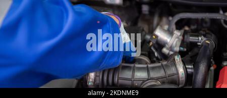 Gros plan mains de l'homme est mécanicien de réparer le moteur de voiture dans le garage, l'auto service, le travailleur de fixer et d'ajuster une partie de l'automobile avec des problèmes dans le Banque D'Images