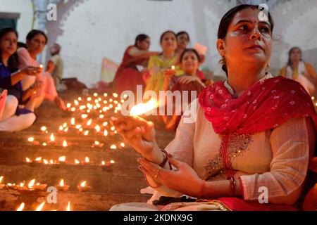 Kolkata, Inde. 07th novembre 2022. Une femme exécute des rituels pendant l'occasion. Les dévotés éclairant des lampes à huile, décorant les ghats, exécutant des rituels sur les rives de la rivière Ganga à l'occasion de Dev Deepawali, itís l'un des plus grands Festival de lumière en Inde. Crédit : SOPA Images Limited/Alamy Live News Banque D'Images