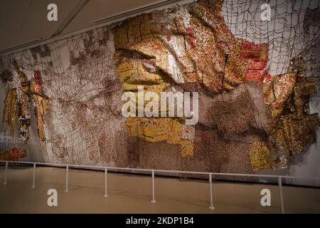 Grande tapisserie en métal faite avec des hauts de bouteille de liqueur jetés par l'artiste africain El Anatsui. Les dessus de bouteille sont des marchandises d'importation et ont un fort hist africain Banque D'Images