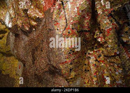 Grande tapisserie en métal faite avec des hauts de bouteille de liqueur jetés par l'artiste africain El Anatsui. Les dessus de bouteille sont des marchandises d'importation et ont un fort hist africain Banque D'Images