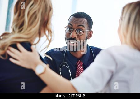 C'est une bonne nouvelle. Un jeune couple ayant une consultation avec son médecin. Banque D'Images