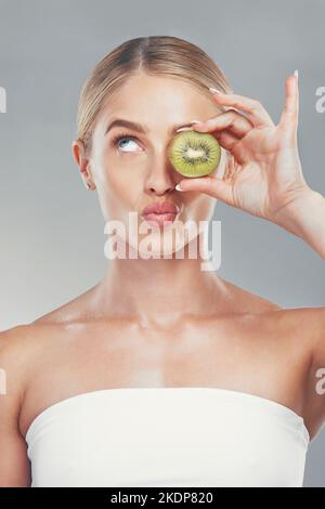 La pensée, la beauté et la femme avec le visage kiwi pour les soins de la peau bio, la santé et le produit cosmétique. Modèle de peau réfléchie fille pour le traitement cosmétique de fruit Banque D'Images