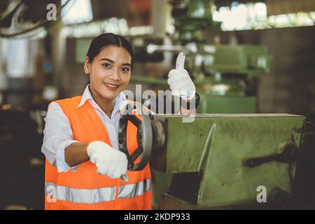 Portrait bonne femme travailleuse travaillant dans l'industrie lourde usine de métal asiatique sourire pouces vers le haut Banque D'Images