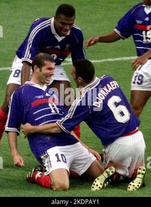 Photo du dossier en date du 11-07-1998 de la France Zinedine Zidane, à gauche, est félicité après avoir marquant le deuxième but par le coéquipier Youri Djorkaeff, à droite, et Marcel Desailly lors de la finale de la coupe du monde 98 entre le Brésil et la France. Alors que l'histoire de Zidane à la coupe du monde s'est terminée par un vif succès lors de la finale de 2006 pour avoir été envoyé au défenseur italien Marco Materazzi, le milieu de terrain français a fait partie intégrante du succès mémorable des Bleus en 1998 à Paris. Date de publication : mardi 8 novembre 2022. Banque D'Images