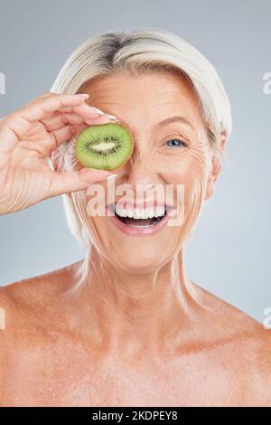Kiwi, fruit et bien-être d'une femme âgée avec soin de beauté, santé et un sourire. Portrait d'un modèle de personnes âgées heureux tenant la nourriture sentant le bonheur Banque D'Images