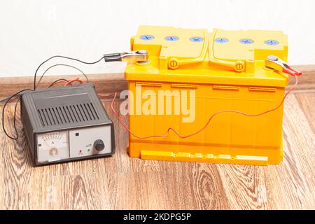 batterie de voiture jaune avec chargeur de batterie de voiture. Banque D'Images