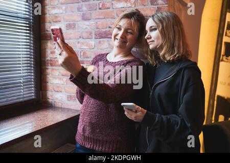 Les femmes qui font des appels vidéo sur leur téléphone mobile. Prendre des photos de selfie à l'aide d'un smartphone. Connexion à distance avec votre famille et vos amis Banque D'Images
