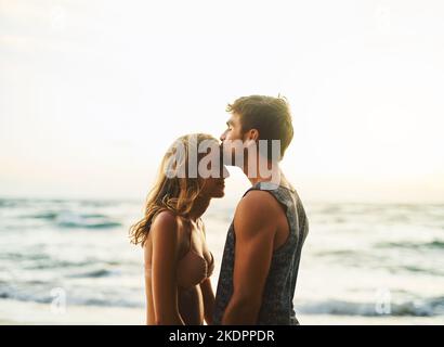 Shes le seul poisson dans la mer. Un jeune couple passant la journée à la plage. Banque D'Images