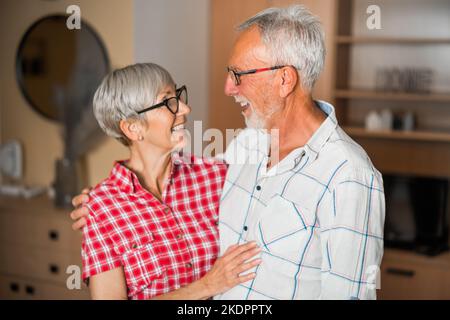 Portrait d'un couple senior heureux à la maison. Les aînés s'embrassent. Banque D'Images