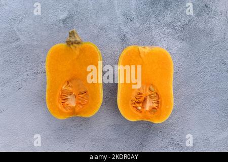 Courge musquée coupée en deux sur fond gris. Banque D'Images