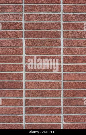 Vue plein cadre d'un mur rectangulaire en briques rouges avec un motif uniforme. Banque D'Images