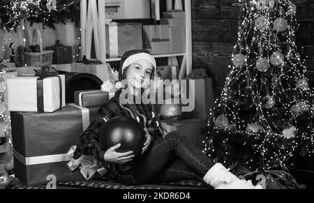 Boutique de décoration. Couleur préférée. Style rouge. Répandre l'amour. Vacances d'hiver. Petite fille mignonne avec grand sapin de noël de boule. Esprit de Noël. Concept de Noël Banque D'Images