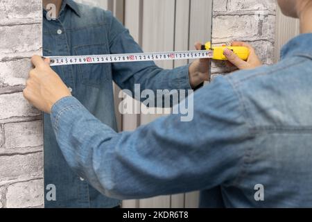 le maître mesure la largeur du miroir. main tenant un mètre ruban. Photo de haute qualité Banque D'Images