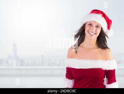 Image de Noël d'une femme caucasienne portant un chapeau de père noël souriant sur un paysage urbain avec un espace de copie Banque D'Images