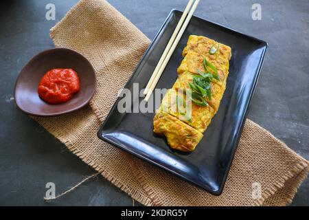 Télur dadar gulung ou Tamagoyaki ou Japaneses rouleau d'oeufs. Gyeran mari ou omelette roulée coréenne. Œuf frit Banque D'Images
