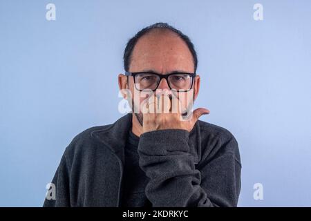 homme de 60 ans avec la main sur la bouche Banque D'Images