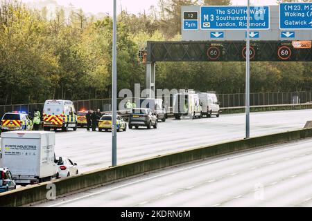 Thorpe, Royaume-Uni. 8th novembre 2022. Les policiers de Surrey retirent un activiste Just Stop Oil d'un portique suspendu au-dessus de l'autoroute M25 entre les jonctions 12 et 13. Il suffit de stopper le trafic sur plusieurs sites le M25 pour une deuxième journée dans le cadre de leur campagne visant à exiger que le gouvernement arrête tous les nouveaux permis et consentements de pétrole et de gaz. Crédit : Mark Kerrison/Alamy Live News Banque D'Images