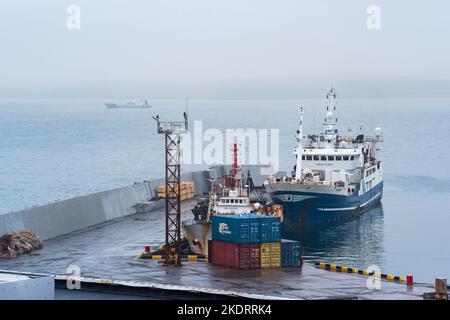 Yuzhno-Kurilsk, Russie - 02 août 2022 : bateau de pêche à la jetée du port sur la rive d'une mer trouble Banque D'Images