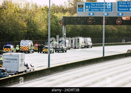 Thorpe, Royaume-Uni. 8th novembre 2022. Les policiers de Surrey retirent un activiste Just Stop Oil d'un portique suspendu au-dessus de l'autoroute M25 entre les jonctions 12 et 13. Il suffit de stopper le trafic sur plusieurs sites le M25 pour une deuxième journée dans le cadre de leur campagne visant à exiger que le gouvernement arrête tous les nouveaux permis et consentements de pétrole et de gaz. Crédit : Mark Kerrison/Alamy Live News Banque D'Images