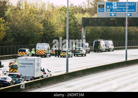 Thorpe, Royaume-Uni. 8th novembre 2022. Les policiers de Surrey retirent un activiste Just Stop Oil d'un portique suspendu au-dessus de l'autoroute M25 entre les jonctions 12 et 13. Il suffit de stopper le trafic sur plusieurs sites le M25 pour une deuxième journée dans le cadre de leur campagne visant à exiger que le gouvernement arrête tous les nouveaux permis et consentements de pétrole et de gaz. Crédit : Mark Kerrison/Alamy Live News Banque D'Images