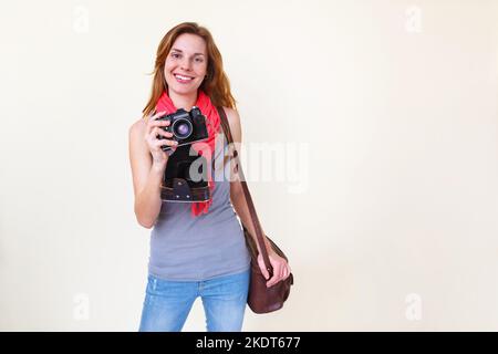 Femme photographe tenant un ancien appareil photo 35mm. Banque D'Images