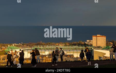 Calton Hill, Édimbourg, Écosse, Royaume-Uni, 8th novembre 2022. Météo au Royaume-Uni : soleil et nuages avec des touristes prenant des photos de la vue à travers le Firth of Forth avec le stade Hibernian football Club en arrière-plan et l'île de mai illuminé au loin. Crédit : Sally Anderson/Alay Live News Banque D'Images