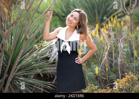 Jeune femme souriante dans une scène désertique entourée par Yucca et Cactus Banque D'Images