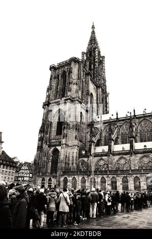 STRASBOURG, FRANCE - 21 DÉCEMBRE 2015 : touristes en file d'attente pour entrer dans la cathédrale notre-Dame pendant les vacances de Noël. Photo historique noir blanc Banque D'Images