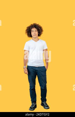 Belle jeune race mixte afro-italien homme dans son 20s, vêtu de vêtements décontractés, devant un fond jaune Banque D'Images