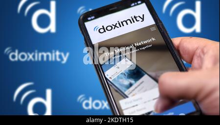 San Francisco, CA, Etats-Unis Mars 2022: Doximaity Company site Web sur un écran de téléphone. Arrière-plan bleu avec le logo de la Doximétrie répétée flou en arrière-plan. Banque D'Images