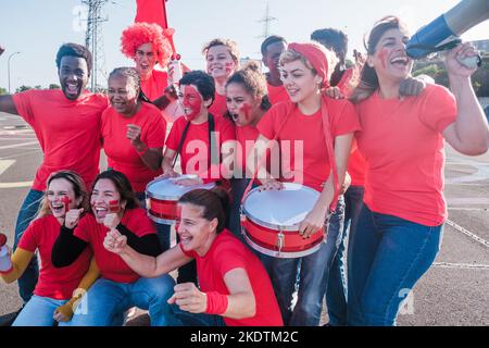 Un groupe de fans venus de différents endroits se réunissaient pour soutenir une équipe et ses couleurs Banque D'Images