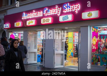 Londres, Royaume-Uni - 6 novembre 2022 : panneau American Candy Shop sur la rue commerçante animée d'Oxford. Banque D'Images