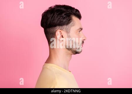 Photo de profil de côté de sérieux positif gars avec brunet coiffure habillé t-shirt jaune look vide espace isolé sur fond rose couleur Banque D'Images