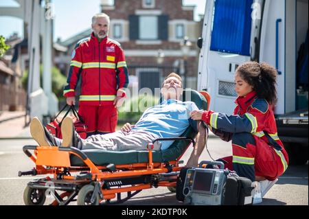 Femme paramédicale fournissant des soins médicaux d'urgence à un patient inconscient Banque D'Images