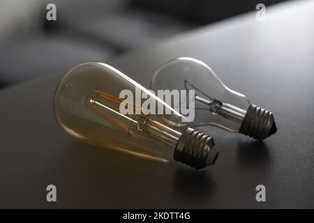 Concept d'économie d'énergie. Ampoule avec lumière allumée sur fond gris. Banque D'Images
