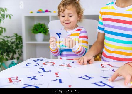 L'enfant apprend des lettres anglaises. Mise au point sélective. Enfant. Banque D'Images