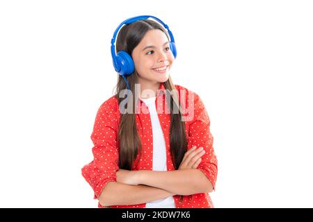 Une jeune fille dans un casque écoute de la musique. Accessoire de casque sans fil. L'enfant aime la musique dans les écouteurs sur fond blanc. Portrait de heureux Banque D'Images