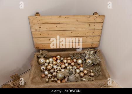 Sur un fond de lumière neutre, une boîte en bois, un coffre au Trésor sous forme de jouets, balles. Fête des pirates à Noël. Intérieur rustique scandinave déc Banque D'Images