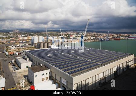 Vue de dessus de l'entrepôt avec panneaux de collecte d'énergie solaire sur le toit, Port de Civitavecchia, région du Latium, Rome, Italie. Banque D'Images