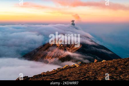 Volcan de Fuego dans les nuages au lever du soleil vu d'Acatenango. Guatemala. Banque D'Images