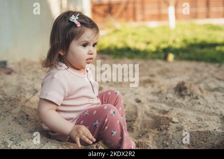 Petite fille caucasienne jouant dans le sable avec son frère, passant du temps libre ensemble. Bonne famille à l'extérieur. Famille amusante. Amuse-toi bien. Banque D'Images
