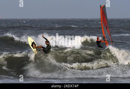 Cocoa Beach, États-Unis. 08th novembre 2022. Une surfeuse et une planche à voile apprécient les vagues rugueuses à Cocoa Beach, en Floride, alors que la tempête tropicale Nicole approche de la côte est de la Floride. La tempête est sur la bonne voie pour devenir un ouragan de catégorie 1 d'ici mercredi. Crédit : SOPA Images Limited/Alamy Live News Banque D'Images